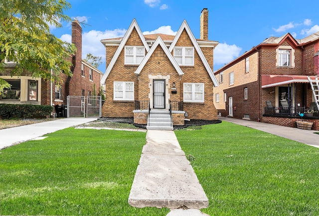 tudor-style house featuring a front yard