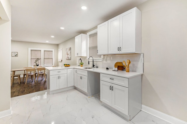 kitchen with white cabinetry, sink, and tasteful backsplash