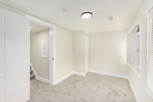 spare room featuring light colored carpet