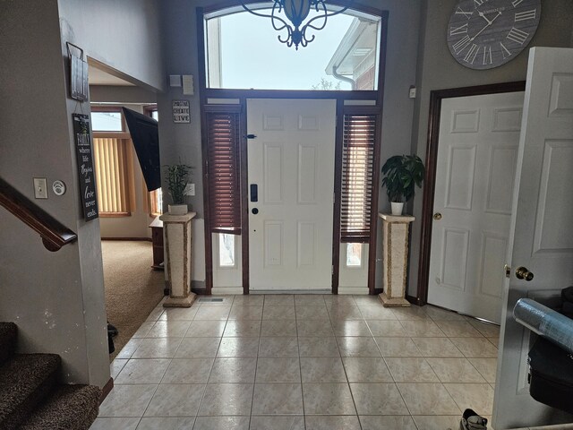 tiled foyer entrance with an inviting chandelier