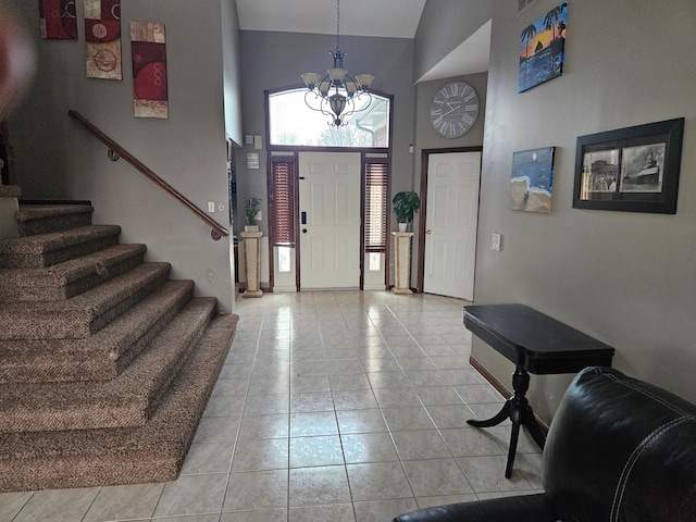 foyer featuring light tile patterned flooring, an inviting chandelier, and high vaulted ceiling