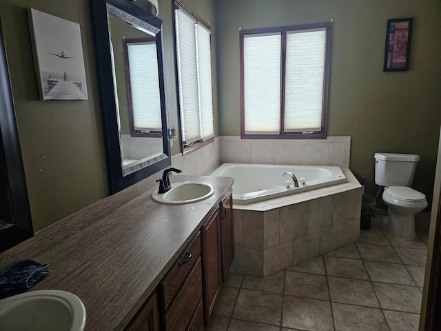 bathroom featuring a relaxing tiled tub, vanity, toilet, and tile patterned flooring