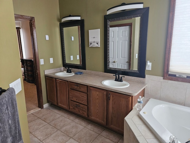 bathroom with a relaxing tiled tub, tile patterned floors, and vanity