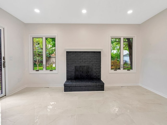 unfurnished living room featuring a brick fireplace and plenty of natural light