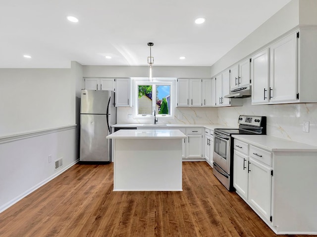 kitchen with appliances with stainless steel finishes, sink, decorative backsplash, and white cabinets