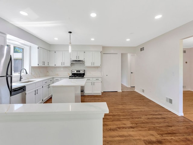 kitchen featuring sink, white cabinets, hanging light fixtures, a center island, and stainless steel appliances