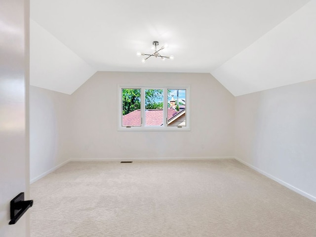 bonus room featuring lofted ceiling, a notable chandelier, and carpet