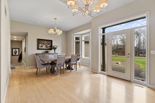 dining room with light hardwood / wood-style floors and a chandelier