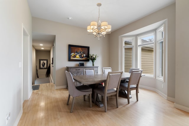 dining room featuring an inviting chandelier and light hardwood / wood-style flooring