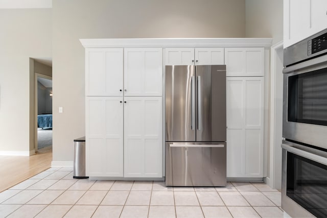 kitchen featuring white cabinetry, light tile patterned floors, and stainless steel appliances