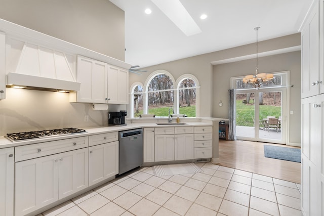 kitchen with white cabinetry, appliances with stainless steel finishes, decorative light fixtures, and light tile patterned floors