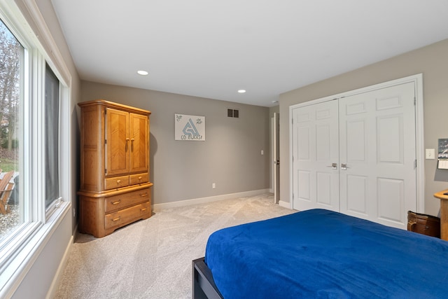 bedroom featuring a closet and light carpet