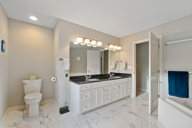 bathroom with vanity, tiled bath, and toilet