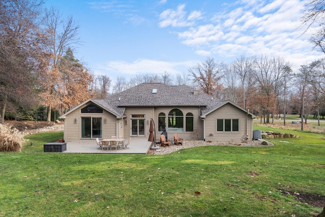 back of property with a yard, central air condition unit, and a patio area