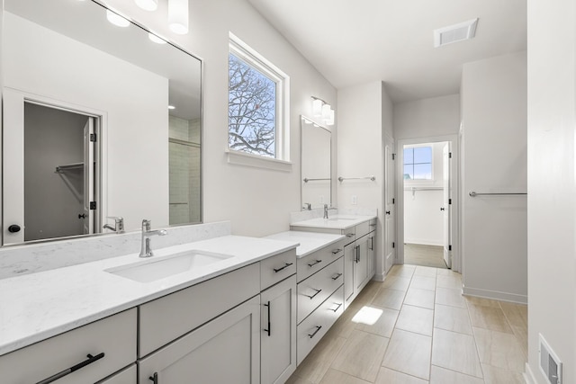 bathroom with vanity, tile patterned floors, plenty of natural light, and a shower with door