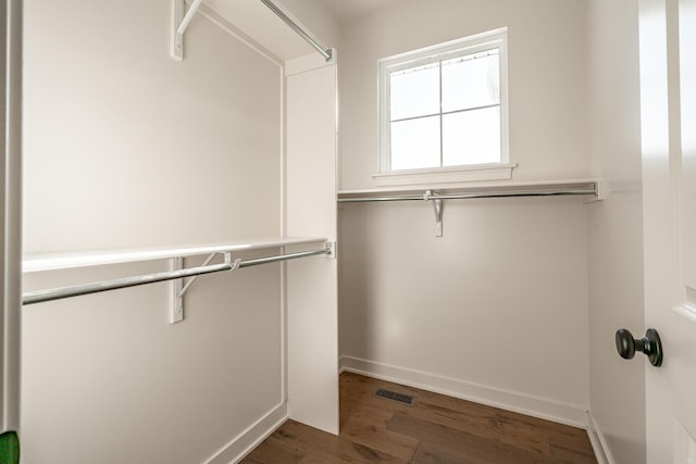 walk in closet with dark wood-type flooring