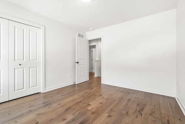 unfurnished bedroom with hardwood / wood-style floors and a closet