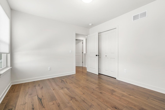 unfurnished bedroom with hardwood / wood-style floors and a closet