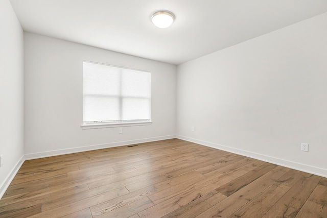 empty room with hardwood / wood-style flooring