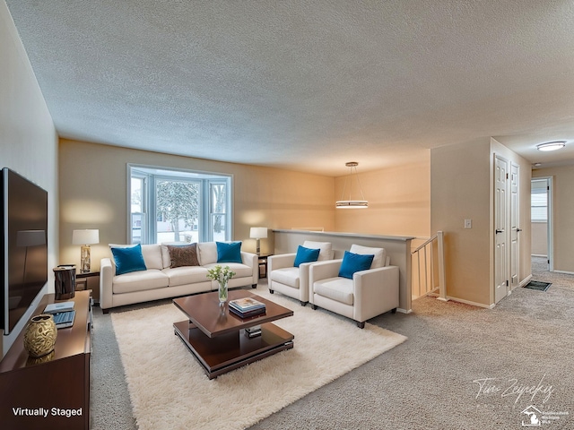 carpeted living room featuring a wealth of natural light and a textured ceiling