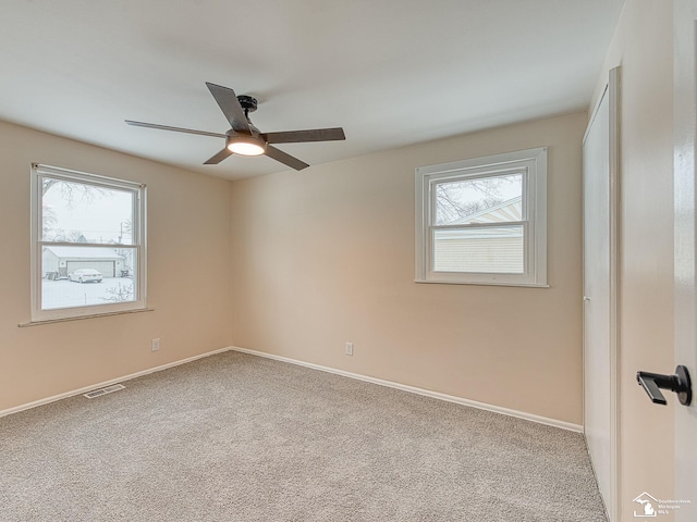 unfurnished room with light colored carpet and ceiling fan