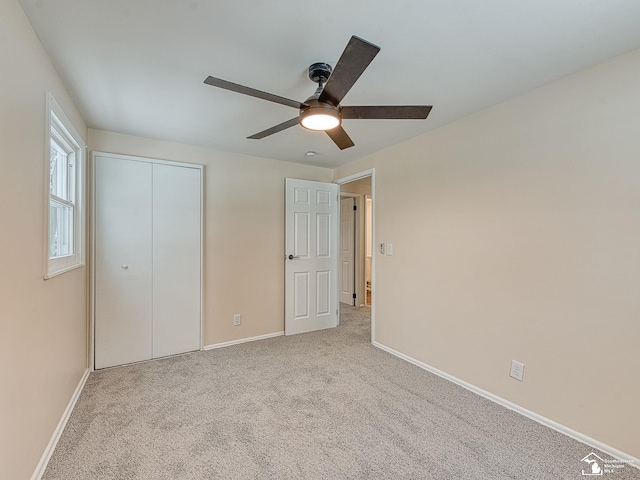 unfurnished bedroom with light colored carpet, ceiling fan, and a closet