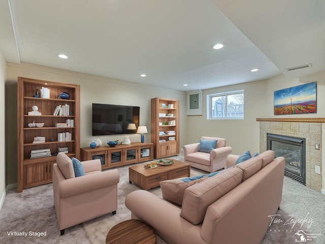 living room featuring light colored carpet and a tile fireplace