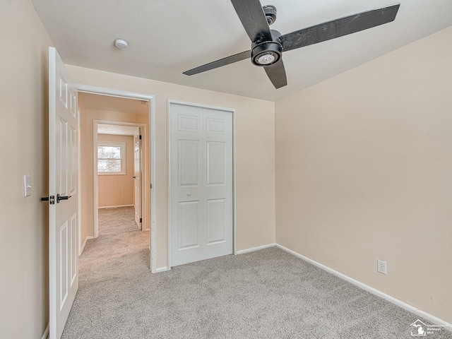 unfurnished bedroom featuring light colored carpet, a closet, and ceiling fan