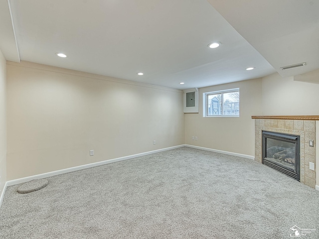 unfurnished living room with a fireplace, electric panel, and carpet flooring