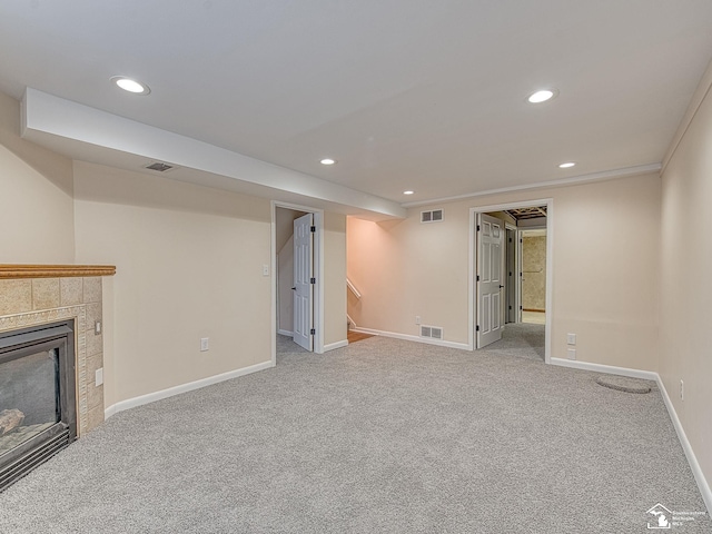 unfurnished living room with light carpet and a tile fireplace