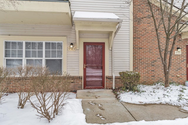 view of snow covered property entrance