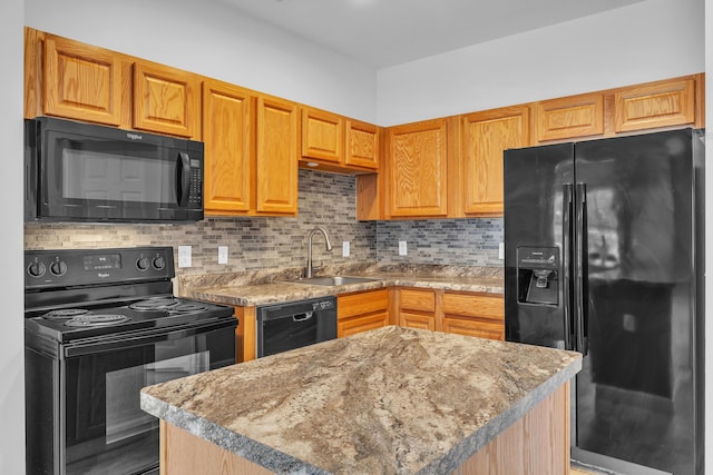 kitchen featuring sink, decorative backsplash, a center island, light stone counters, and black appliances