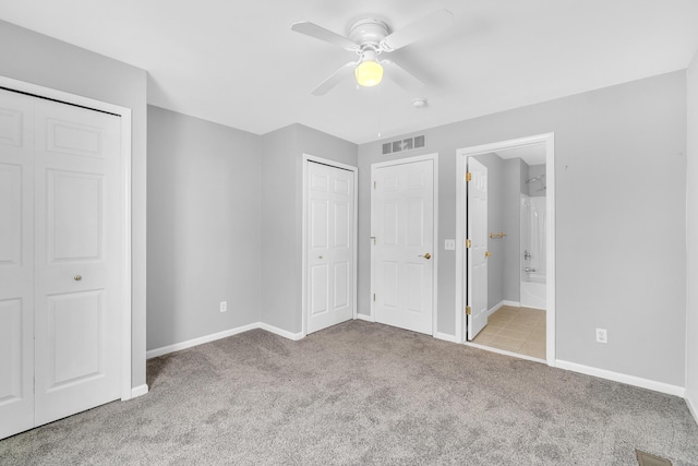 unfurnished bedroom featuring light carpet, ensuite bath, and ceiling fan