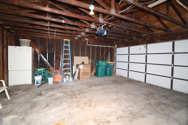 garage featuring a garage door opener and white fridge