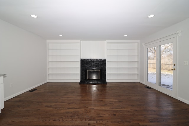 unfurnished living room featuring dark hardwood / wood-style flooring and built in features