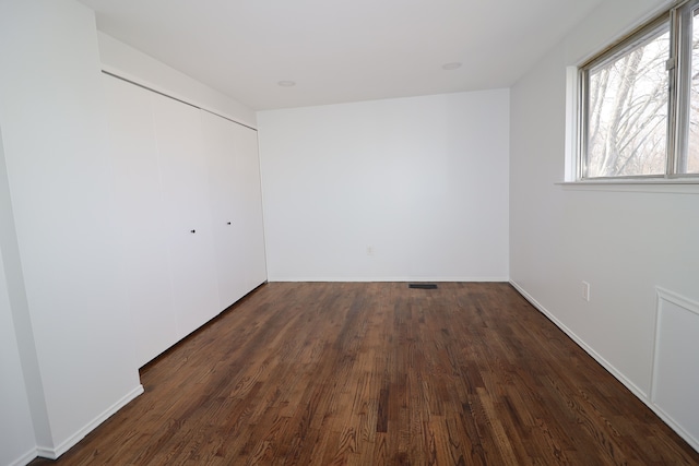 unfurnished room featuring dark wood-type flooring