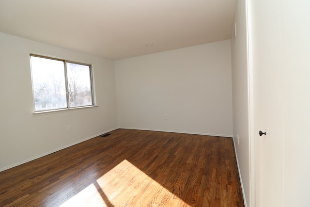 spare room with dark hardwood / wood-style floors