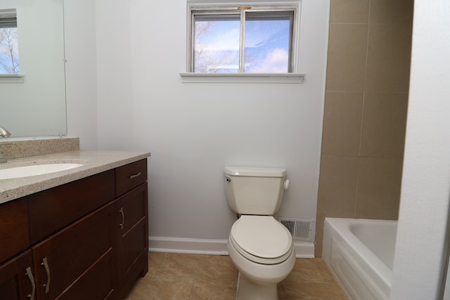 bathroom featuring vanity, a washtub, tile patterned flooring, and toilet