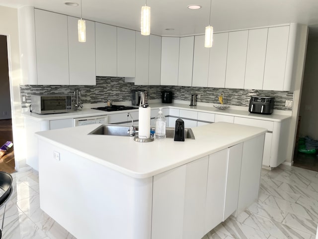 kitchen with pendant lighting, an island with sink, decorative backsplash, and white cabinets