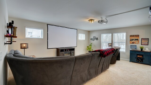 cinema with plenty of natural light, light colored carpet, and baseboards