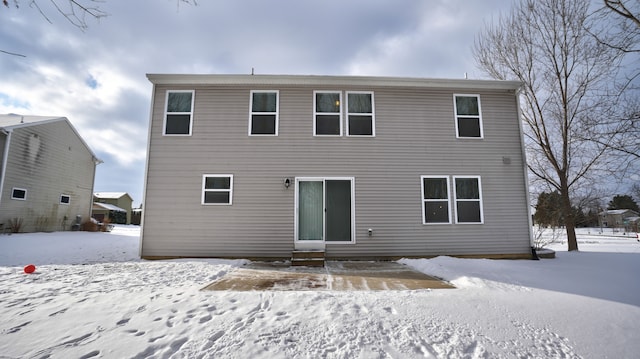 view of snow covered back of property