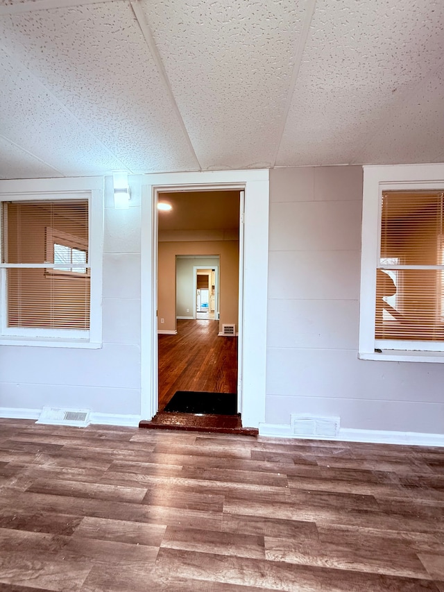 empty room featuring wood-type flooring and wood walls