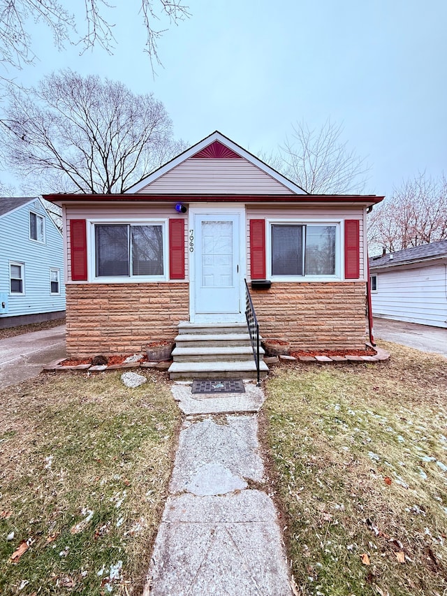 bungalow-style home featuring a front lawn