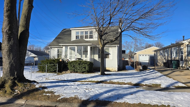 view of front of home featuring a garage and an outbuilding