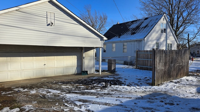 view of snow covered exterior featuring a garage