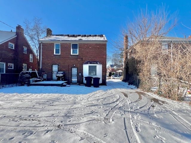 view of snow covered rear of property