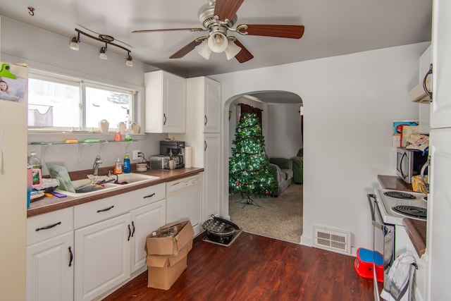 kitchen featuring sink, white appliances, dark wood-type flooring, ceiling fan, and white cabinets