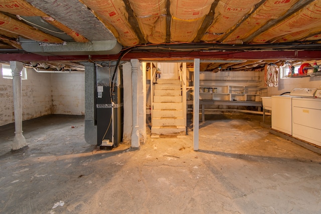 basement featuring washer and clothes dryer and heating unit