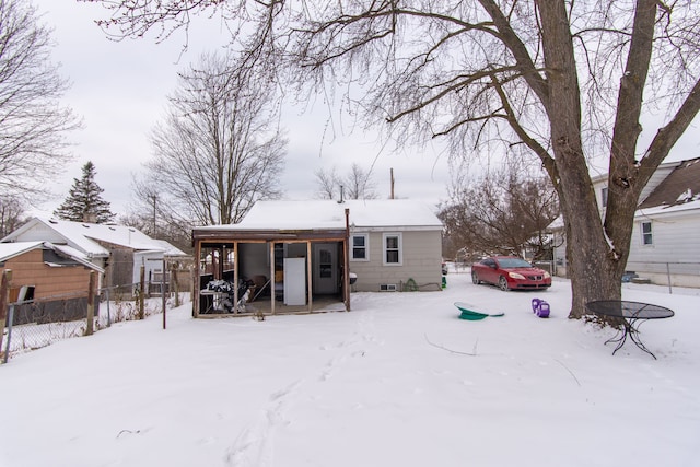 view of snow covered back of property