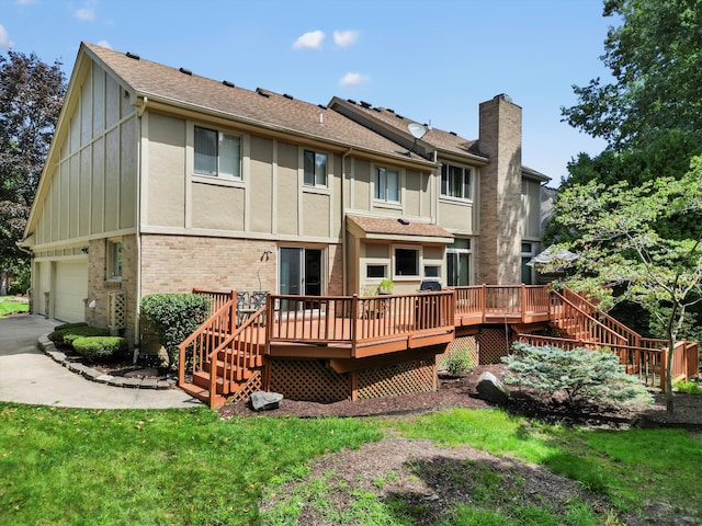 rear view of property featuring a garage, a yard, and a deck